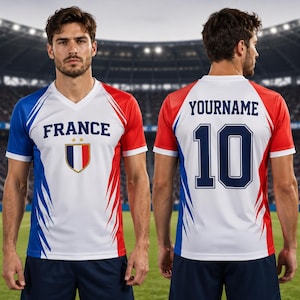A man wearing a red, white, and blue soccer jersey with the word "FRANCE" printed on it, standing in front of a soccer stadium.