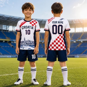 A young boy wearing a white and red soccer jersey with the word "Cratia" and the number 10, standing on a soccer field.