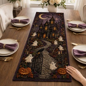 May include: A rectangular table runner featuring a dark purple and black Halloween scene with a haunted mansion, a stone path, glowing jack-o'-lanterns, and several white ghosts. The design includes a crescent moon, bare trees, and a black crow.
