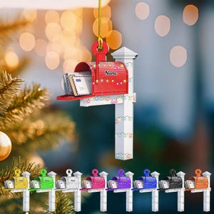 May include: A red mailbox ornament with the word "Name" on the side, filled with miniature letters. The mailbox is decorated with a string of colorful lights and hangs from a gold string. Below are several miniature mailboxes in various colors.