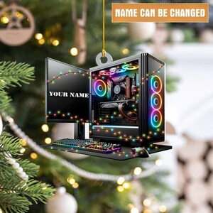 May include: A computer-themed Christmas ornament featuring a desktop computer, monitor, and keyboard. The monitor displays "YOUR NAME" and the text "NAME CAN BE CHANGED" is at the top. The ornament is decorated with colorful lights.