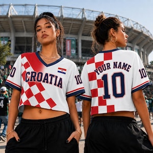 A woman wearing a red and white Croatia soccer jersey with the number 10, standing in front of a stadium.