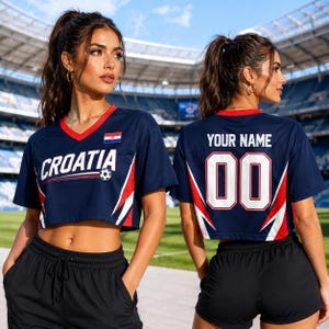 A woman wearing a Croatia soccer jersey with the name "Cristiano" and the number "00" on the back, standing in front of a stadium.