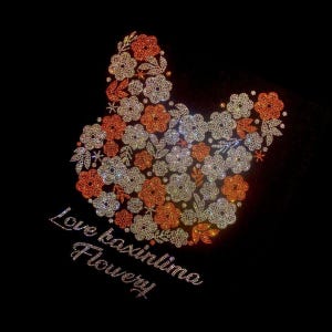 May include: A floral design in the shape of a bunny head, composed of orange and white sparkling rhinestones, set against a black background. The text "Love taxinlina Flowery" is written in cursive below the design.