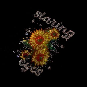 May include: A black t-shirt with a rhinestone design featuring three sunflowers, the word "starving" and the word "yes".