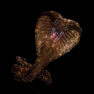 May include: A golden cobra pendant, encrusted with sparkling gemstones. The snake's head is raised, revealing a detailed mouth with pink and blue accents. The design is set against a black background, highlighting the jewelry's brilliance.