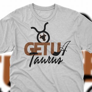 Puede incluir: Una camiseta gris con un símbolo del zodiaco Tauro marrón y el texto "GET U A Taurus" en negro.