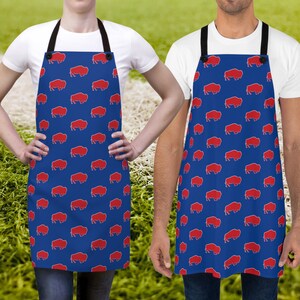 May include: Two blue aprons featuring a red buffalo silhouette pattern. The aprons have adjustable neck straps and a large pocket on the front.