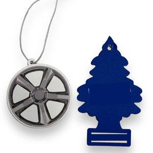 May include: Two car air fresheners, one shaped like a car wheel and the other shaped like a Christmas tree. The wheel is silver and gray, and the tree is blue.