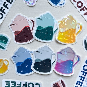 May include: A set of six stickers featuring camping coffee mugs and coffee pots. The stickers are holographic and have a galaxy design. The stickers are on a white background. The text on the stickers reads "Campin' Coffee".