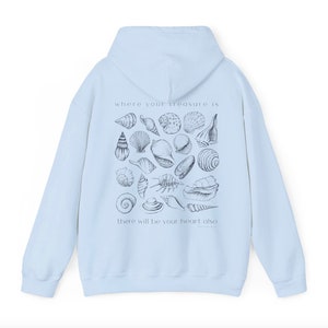 Puede incluir: Sudadera con capucha azul claro con un estampado gr&aacute;fico de conchas marinas y el texto "where your treasure is there will be your heart also".