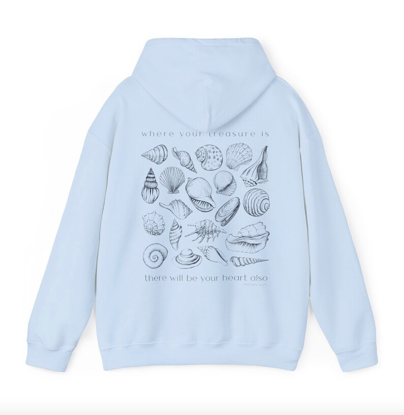 Puede incluir: Sudadera con capucha azul claro con un estampado gr&aacute;fico de conchas marinas y el texto "where your treasure is there will be your heart also".