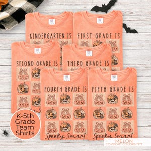 May include: Melon-colored t-shirts with Halloween-themed designs. Each shirt is printed with a grade level, pumpkins, and the words "Spooky Smart." The shirts are for Kindergarten through 5th grade.
