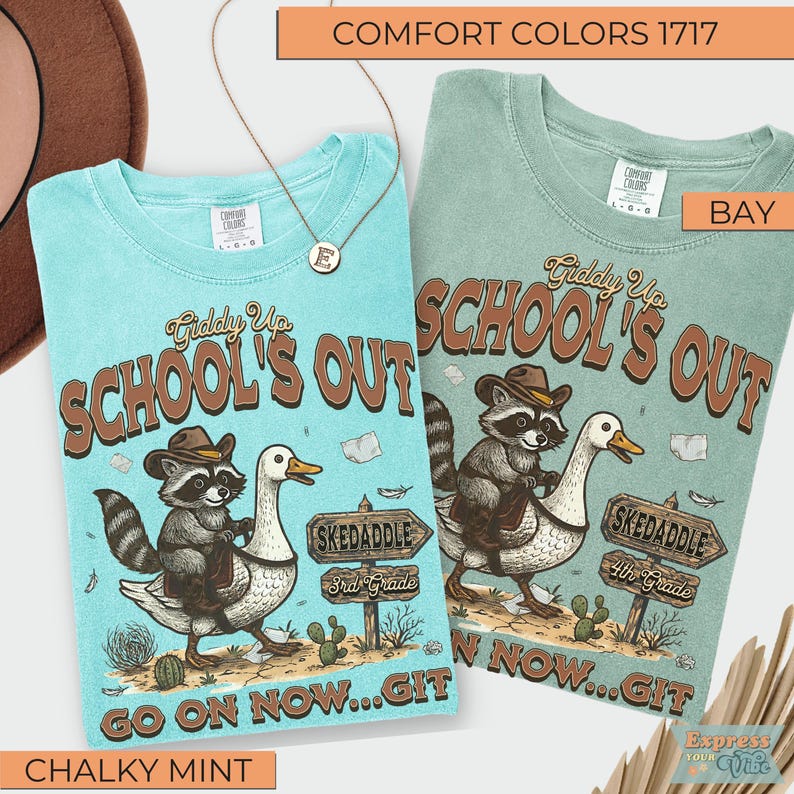 May include: Two Comfort Colors t-shirts, one chalky mint and one bay, with a graphic of a raccoon riding a goose. The shirts have the text "Giddy Up School's Out" and "Go on now...Git". A gold necklace with an "E" pendant is also visible.