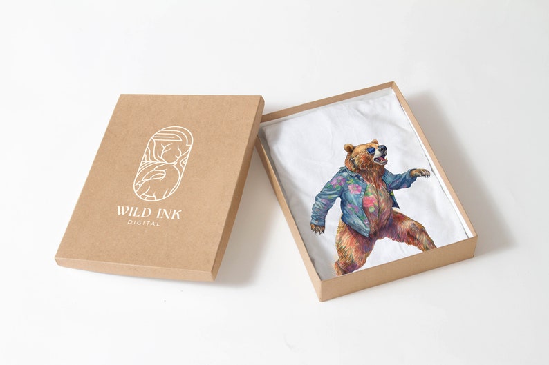 May include: A brown cardboard box with the text "WILD INK DIGITAL" on the front. The box is open and a white t-shirt with a colourful illustration of a bear wearing sunglasses and a floral shirt is inside.