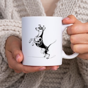 May include: White ceramic mug with a black and white line drawing of a dog standing on its hind legs. The dog has a long tail and is looking to the left.