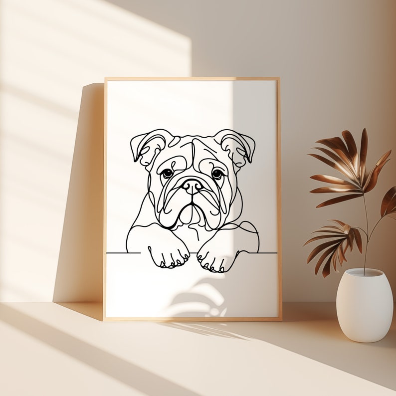 May include: Line art drawing of a bulldog's head with its paws resting on a white surface. The drawing is in black and white and is framed in a light wood frame.