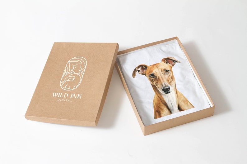 Puede incluir: Una caja de cart&oacute;n marr&oacute;n con un logotipo blanco que dice "WILD INK DIGITAL". La caja est&aacute; abierta y dentro hay una camiseta blanca con una ilustraci&oacute;n de un perro marr&oacute;n y blanco.
