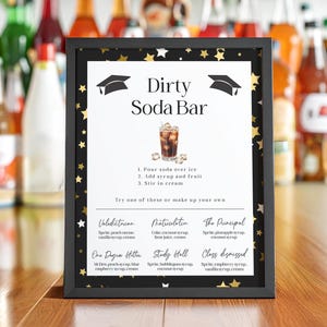 Op de afbeelding: Een ingelijst bord voor een "Dirty Soda Bar" met een zwart frame, gouden sterren en een afstudeerpet-afbeelding. Het bord bevat instructies en drankrecepten. Verschillende frisdrankflessen staan op de achtergrond.