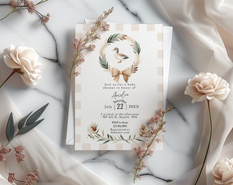 May include: A baby shower invitation with a pink and white gingham background. A watercolor wreath with a duck and a bow is at the top. The text reads "Join us for a baby shower in honor of Amelia Saturday July 22 20XX 3 o'clock in the afternoon 987 6th St. Seattle, WA RSVP to Anne 123-456-7890 Registered at Amazon.com"