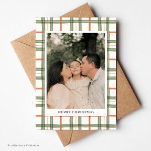 K&ouml;nnte beinhalten: Weihnachtskarte mit einem Familienfoto in einem gr&uuml;n-orangen Karomuster. Die Worte "MERRY CHRISTMAS" sind am unteren Rand des Fotos aufgedruckt. Die Karte befindet sich in einem braunen Umschlag.