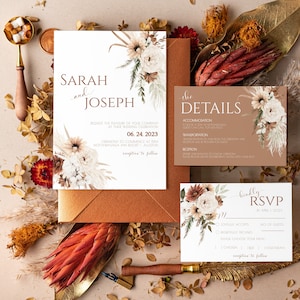Peut inclure: Une suite d'invitation de mariage sur le thème rustique et bohème. L'invitation présente un motif floral avec des herbes séchées et de la pampa dans des tons de brun, beige et blanc. Le texte de l'invitation indique "Sarah et Joseph" et comprend la date et le lieu du mariage. La carte RSVP présente un motif floral similaire et comprend des options pour que les invités répondent à l'invitation et choisissent leur repas.