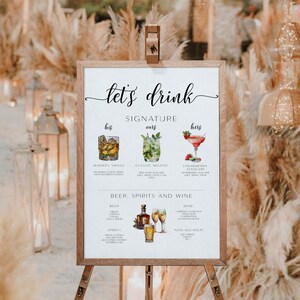 May include: A white sign with the text "let's drink" in black cursive font. The sign lists signature drinks for a wedding, including "Whiskey Smash", "Classic Mojito", and "Strawberry Daiquiri". The sign also lists beer, spirits, and wine options.