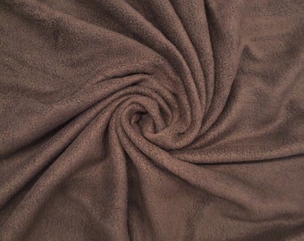 May include: A close-up of a brown fleece fabric, showing the soft texture and the way it drapes.