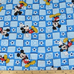 May include: Blue and white checkered fabric with a repeating pattern of Mickey Mouse characters and stars. The fabric is perfect for quilting, crafts, and other sewing projects.