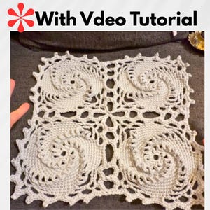 Peut inclure: Nappe carrée en crochet blanc cassé avec quatre motifs en spirale et une bordure ajourée. Le texte "With Video Tutorial" est en haut. Le napperon est fait à la main et présente un motif délicat et complexe.