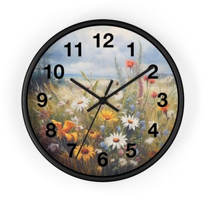 May include: A round wall clock with a black frame and a colorful floral design. The clock face features black Roman numerals and black hands.
