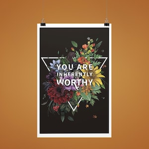 May include: A poster with a black background featuring a floral arrangement in shades of red, purple, yellow, and blue. A white triangle frames the flowers, with the words "YOU ARE INHERENTLY WORTHY" in white.