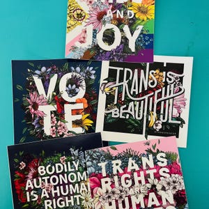 May include: Four colorful stickers with floral designs and text. The stickers say "Vote", "Trans is Beautiful", "Bodily Autonomy is a Human Right", and "Trans Rights are Human Rights".