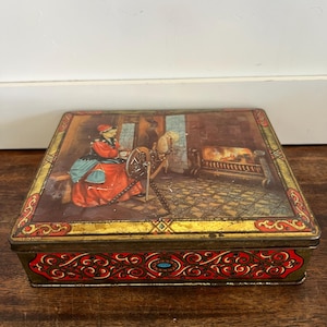 Lovely Antique Biscuit Tin featuring a woman spinning cloth