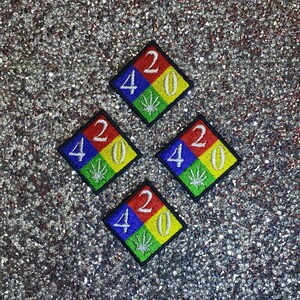 May include: Four colorful diamond-shaped patches with the number 420 in white lettering and a green marijuana leaf in the center.
