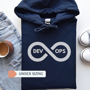 May include: A navy blue hoodie with a white infinity symbol graphic that says "DevOps" inside the symbol. The hoodie has a drawstring hood and a kangaroo pocket. The hoodie is on a white surface with a pair of white sneakers and a pair of blue jeans.