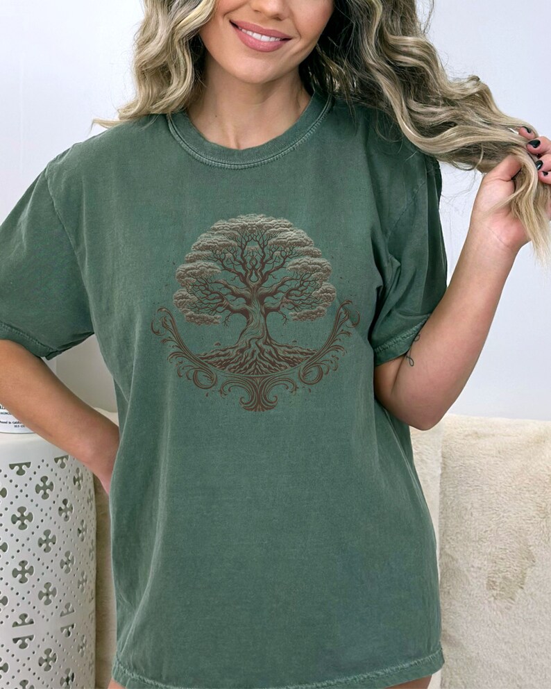 May include: A green t-shirt with a brown tree of life design. The tree has intricate roots and branches.