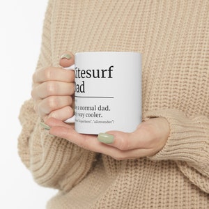 May include: White ceramic mug with black text that reads "Kitesurf Dad" and a definition: "Like a normal dad. Only way cooler. [Kitesurfer, superhero, allrounder]"