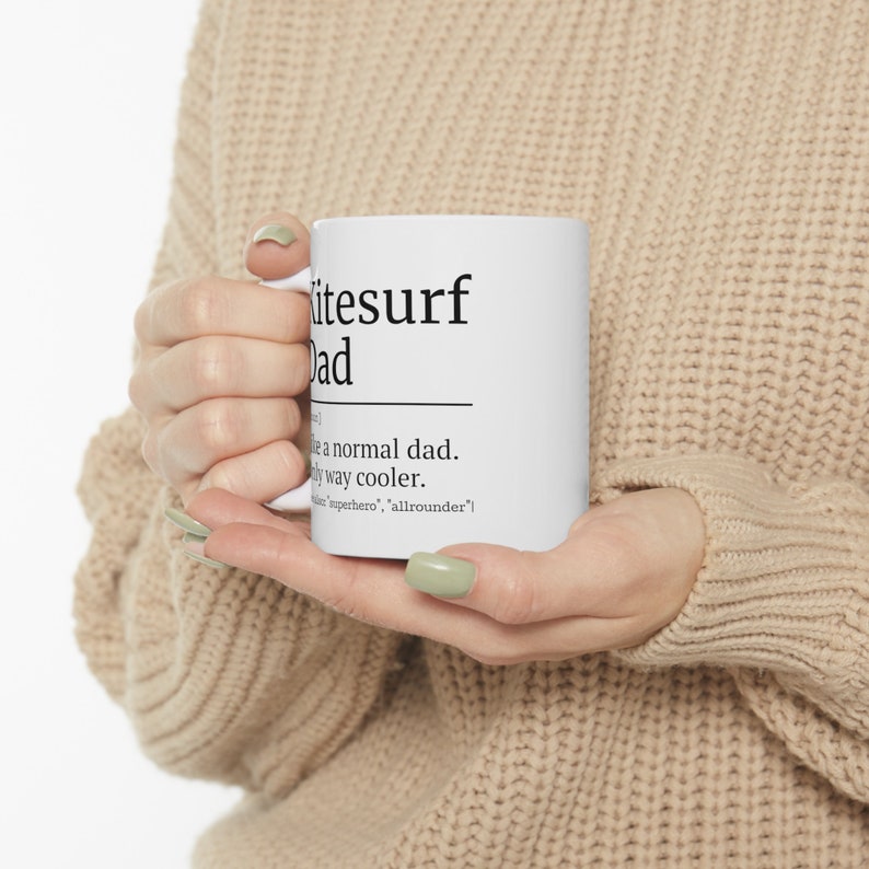 May include: White ceramic mug with black text that reads "Kitesurf Dad" and a definition: "Like a normal dad. Only way cooler. [Kitesurfer, superhero, allrounder]"