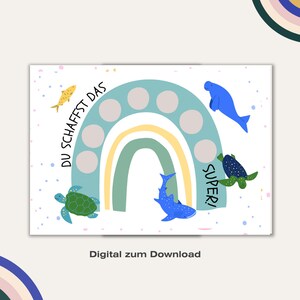 May include: A printable rainbow-themed reward chart with the text "DU SCHAFFST DAS SUPER!" and a variety of sea creatures including a fish, a manatee, a shark, and a turtle. The chart has 10 circles to be filled in as a reward system.