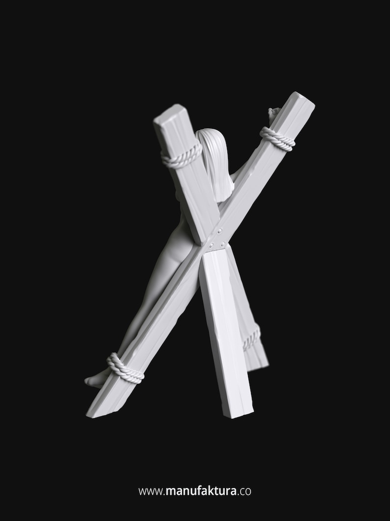 May include: White painted wooden figure of a person tied to a wooden cross. The figure is tied at the wrists and ankles with rope. The cross is made of four pieces of wood, with the two longer pieces forming the cross shape and the two shorter pieces forming the base.