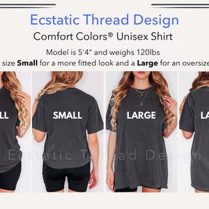 Op de afbeelding: Een antracietkleurig Comfort Colors unisex T-shirt. De afbeelding toont het shirt in de maten Small en Large, gedragen door een model. De tekst op het shirt luidt "SMALL" en "LARGE". Het shirt maakt deel uit van de Ecstatic Thread Design collectie.