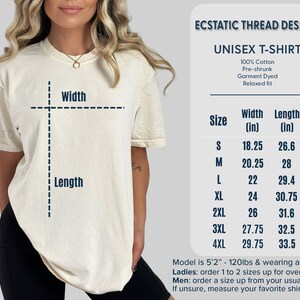 K&ouml;nnte beinhalten: Gr&ouml;&szlig;entabelle f&uuml;r Unisex-T-Shirts mit Ma&szlig;en in Zoll. Die Tabelle zeigt die Breite und L&auml;nge des Shirts in verschiedenen Gr&ouml;&szlig;en von S bis 4XL. Das Model tr&auml;gt ein Shirt in Gr&ouml;&szlig;e M.