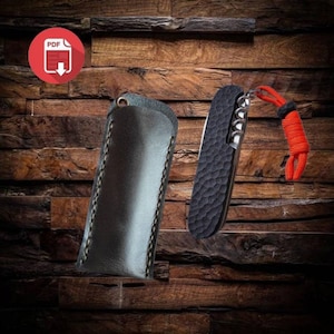 May include: A black leather case with stitching and a black pocket knife with a textured handle and a silver blade. The knife has a red lanyard attached to it.