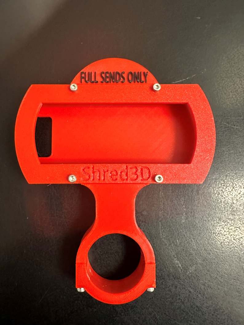 Peut inclure: Support de t&eacute;l&eacute;phone rouge imprim&eacute; en 3D avec une base circulaire et un support de t&eacute;l&eacute;phone rectangulaire. Le support porte l'inscription "FULL SENDS ONLY" et "Shred3D".