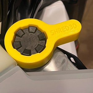 May include: Yellow plastic tool with a black cap and the text "SHRED3D" printed on the handle. The cap has the text "CLOSE TO TURN & PUSH" printed on it.