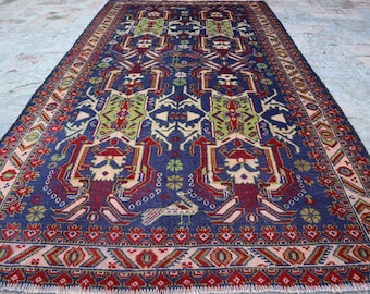 May include: A traditional rug with a blue background and intricate geometric patterns in red, green, and white. The rug has a fringed edge.