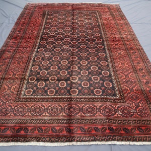 May include: A traditional Persian rug with a dark red and black color scheme. The rug features a central medallion with intricate floral patterns and a border with geometric designs.