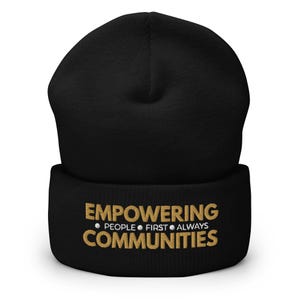 May include: Black beanie with the text "EMPOWERING PEOPLE FIRST ALWAYS COMMUNITIES" in gold lettering. The beanie is a soft, knitted hat, perfect for cold weather.