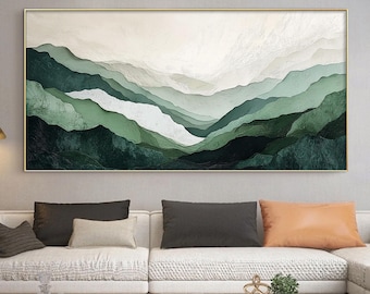 May include: A large abstract painting of green and white mountains in a modern living room setting. The painting is hanging above a white sectional sofa with pillows and a marble coffee table.
